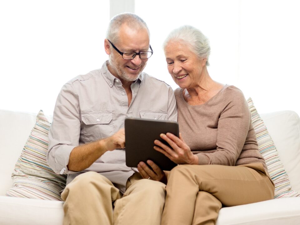 Smiling elderly woman with caregiver in a cozy assisted living home