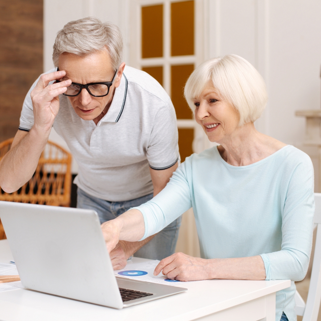Seniors reading health tips and event calendars in a cozy retirement community lounge