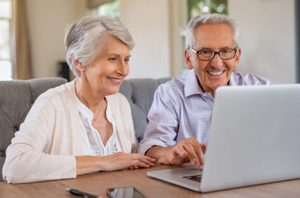 Senior couple using a laptop to search for assisted living options online