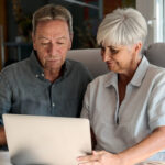Family researching senior housing options online on laptop
