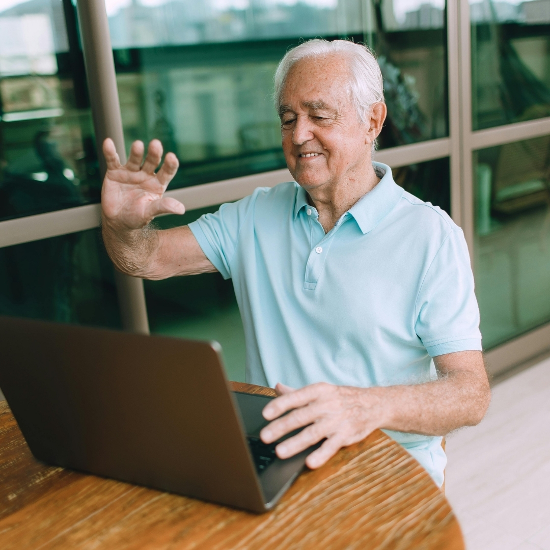 Senior participating in a virtual tour or webinar on a laptop