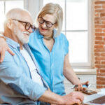 Senior using tablet in modern retirement community lounge