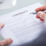 Business professional reviewing government contract documents and compliance requirements.